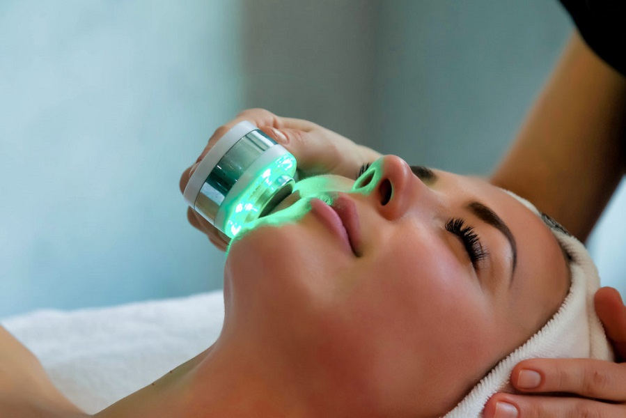 Beautician doing led light therapy to woman in SPA salon, facial phototherapy for skin pore cleaning. Anti-aging treatments and photo rejuvenation procedure. Lady getting face therapy in SPA resort | Kay Dermatology in Burbank, CA