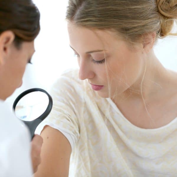 Doctor inspecing Young Girl Skin