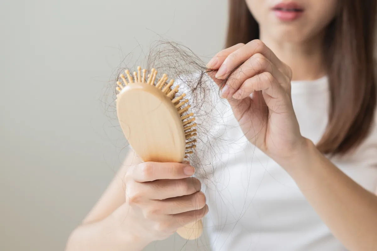 Patient Holding Hair Brush and Looking For Hair Loss Treatment in Burbank CA
